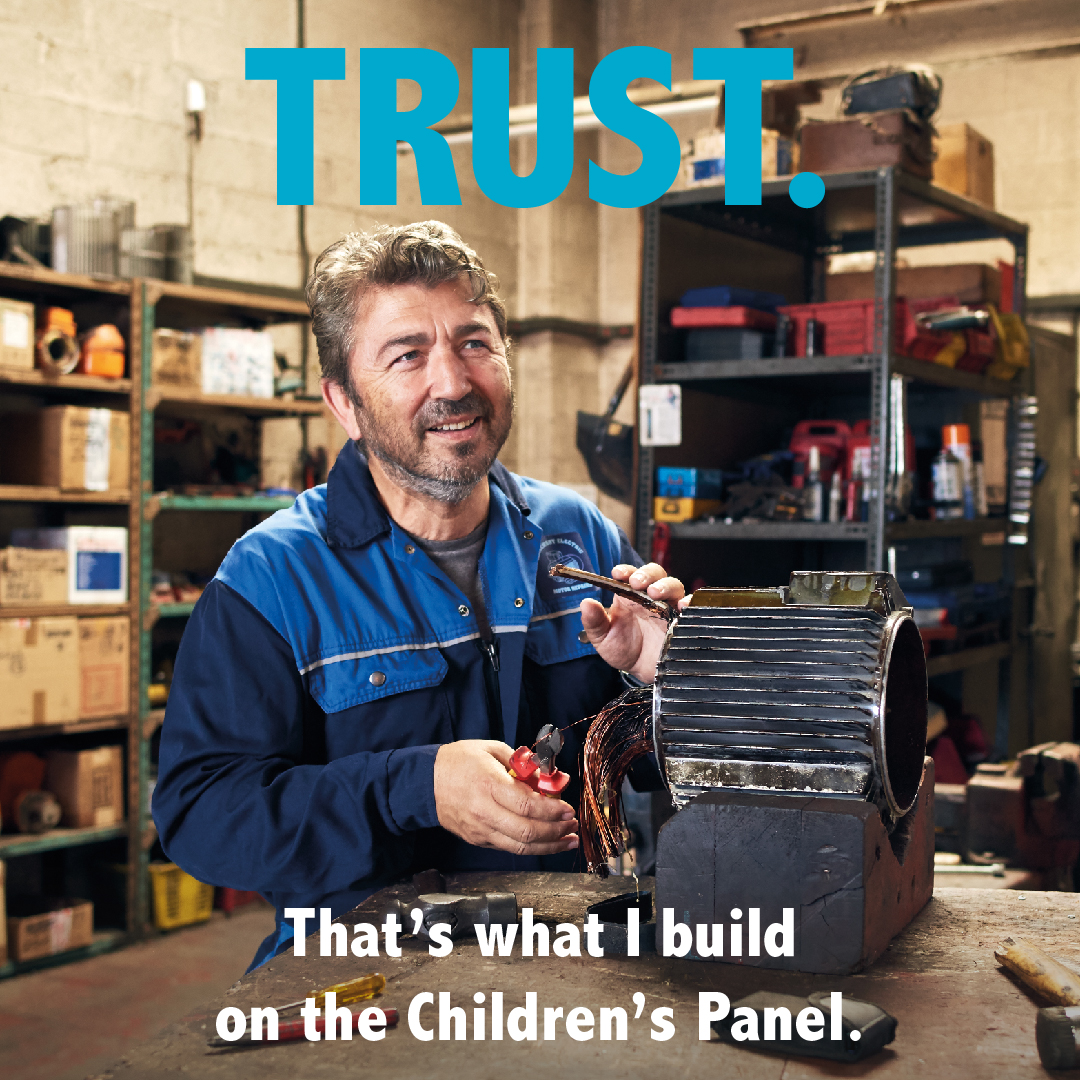 A mechanic working in a workshop, with the word Trust above them.