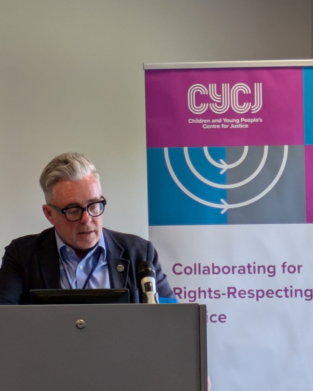 Elliot Jackson, speaking on a podium at the National Youth Justice Conference.